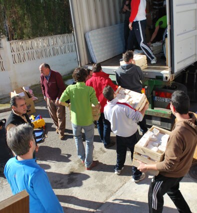 Los voluntarios cargan las cajas con jabón casero 